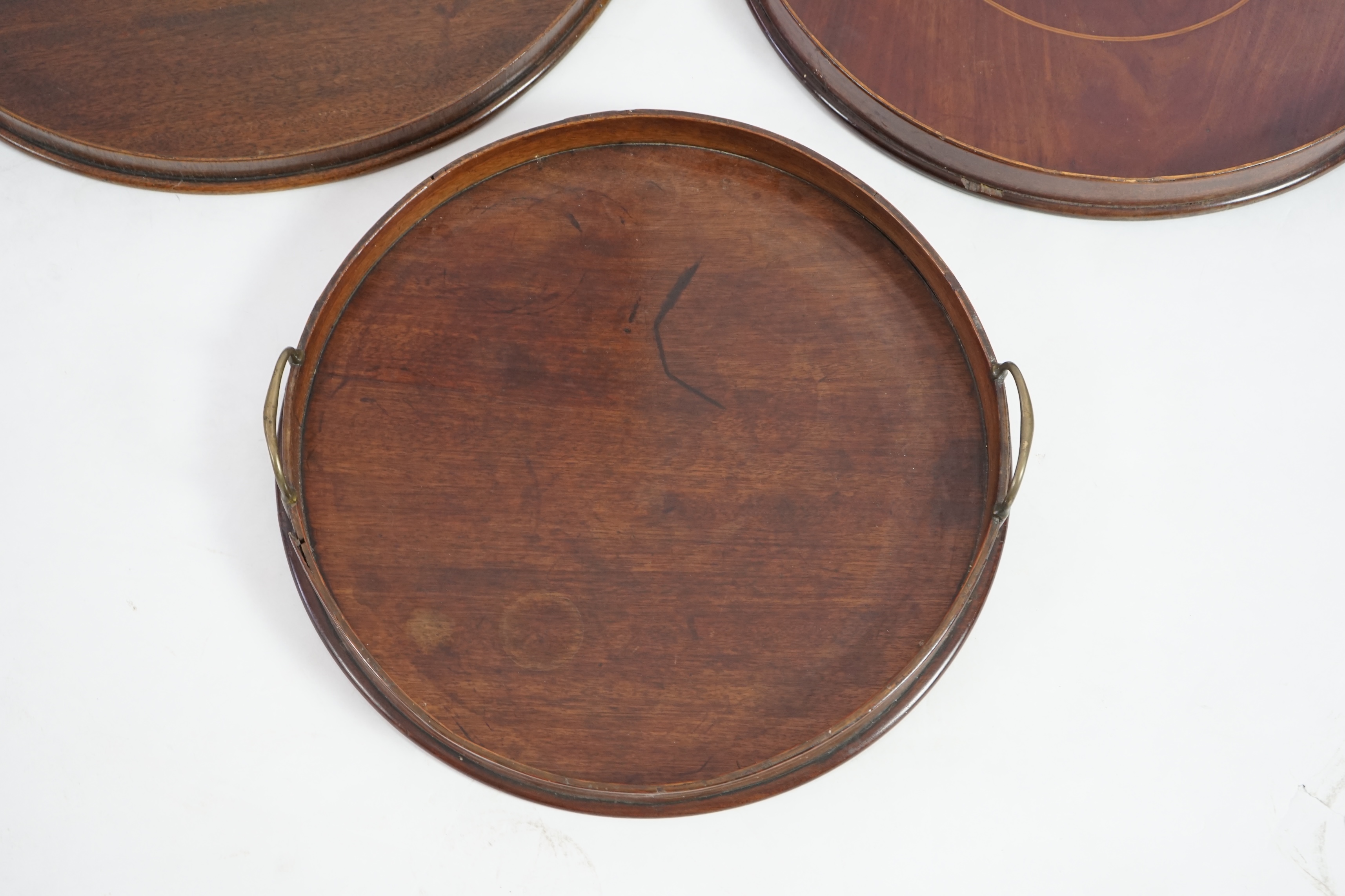 Three George III and later circular mahogany gallery trays